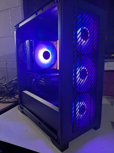 Ryzen 5 7600/32GB DDR5/1TB SSD/RX7600 XT 8GB A computer case featuring three blue LED fans and a glowing interior.