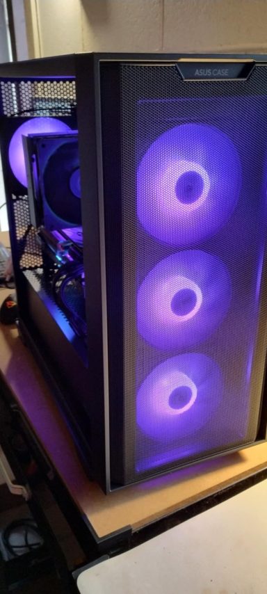 Ryzen 5 7600/64GB DDR5/2TB SSD/RX7800 XT 16GB A black computer case with three glowing purple fans and visible internal components.