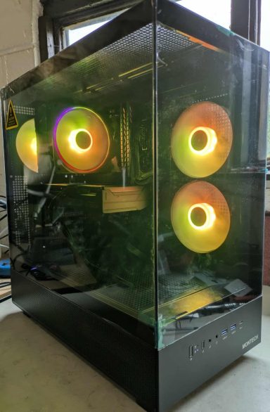 Ryzen 5 3600/16GB DDR4/1TB SSD/RX9060 XT 8GB A sleek gaming PC case with RGB fans glowing in orange and green.