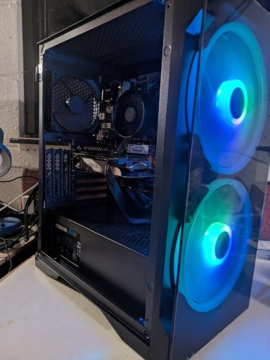 Ryzen 5 1600X/16GB DDR4/1TB SSD/GTX960 4GB A black computer case with blue LED fans and a transparent side panel.