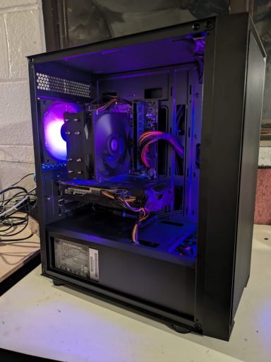 Intel Core i7-4770/16GB DDR3/512GB SSD/GTX1060 6GB A computer case with internal components lit by purple LED lights.