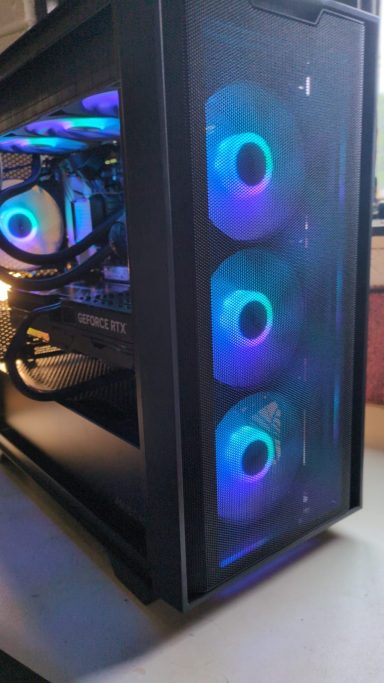 Ryzen 7 9800X3D/64GB DDR5/2TB SSD/RTX5070 Ti 16GB A black computer case with three illuminated cooling fans.