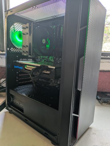 Intel Core i5-4690K/16GB DDR3/512GB SSD/RX580 8GB A sleek black computer case with a green fan and visible interior components.