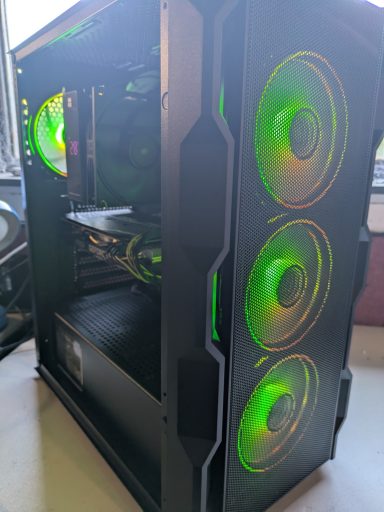 Ryzen 5 3600X/16GB DDR4/512GB SSD/RTX2060 Super 8GB A black computer tower with green LED fans and transparent side panel.