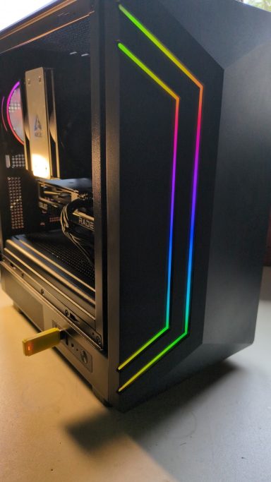 Ryzen 5 5600/32GB DDR4/1TB SSD/RX7600 8GB Black computer case with colourful LED strips and an open side panel.
